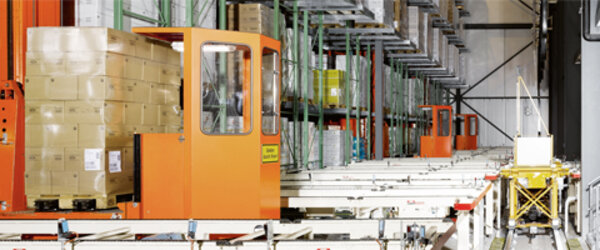 Ein in die Jahre gekommenes Lager - 3 orange Regalbiengeräte mit anschließender Fördertechnik Ein in die Jahre gekommenes Lager - 3 orange Regalbiengeräte mit anschließender Fördertechnik