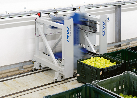 The transfer car s transporting a crate with apples from the sorting system to the high-bay warehouse